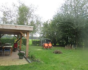 Geniet van de groene tuin en het overdekte terras bij Vakantiehuis in Drouwen, gelegen in het serene Noord Drenthe, Drenthe.