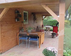 Geniet van de rustieke veranda van Vakantiehuis in Drouwen, gelegen in de groene omgeving van Noord Drenthe, Drenthe.