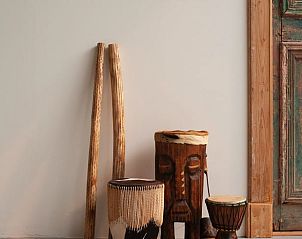 Decoratieve houten trommels in Huisje in Buinerveen, vakantiehuis in Drenthe, geven een exotische sfeer.