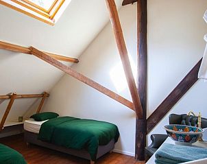 Gezellige zolderkamer met houten balken in Huisje in Buinerveen, vakantiehuis in Drenthe.