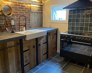 Rustieke keuken in Huisje in Buinerveen, vakantiehuis in Drenthe, met houten kasten en fornuis.