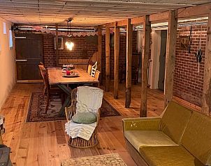 Sfeervolle kelderruimte in Huisje in Buinerveen, vakantiehuis in Noord Drenthe, met houten balken en lange tafel.