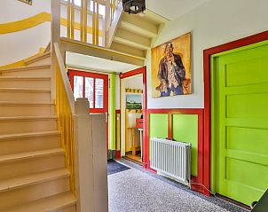 Kleurrijke entree in Vakantiehuisje in Altena, Noord Drenthe, met trap en schilderijen.