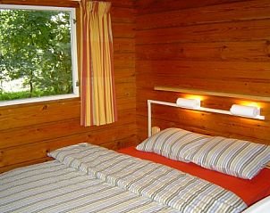 Slaapkamer met tweepersoonsbed in Finse bungalow, Meppen, Drenthe, met uitzicht op de natuur.