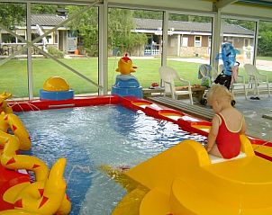 Kinderzwembad bij Finse bungalow, Meppen, Drenthe, met kleurrijke speeltoestellen.