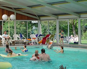 Groot zwembad bij Finse bungalow in Meppen, Drenthe, met families die genieten van het water.
