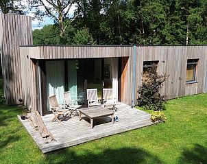 Moderne woonkamer in DG357 vakantiehuis in Meppen, Drenthe met TV en planten.