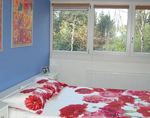 Slaapkamer in Vakantiehuis in Meppen met kleurrijk beddengoed en uitzicht op de bossen van Zuidoost Drenthe.