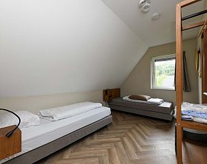 Ruime slaapkamer in Vrijstaande woning in AALDEN met houten vloer.