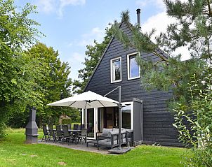 Terras van Vrijstaande woning in AALDEN, vakantiehuis in Zuidoost Drenthe, met comfortabele zitplaatsen en parasol.
