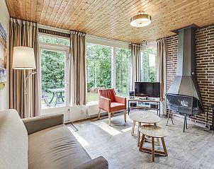 Cozy living room of Aelderholt 2-person bungalow 2C in Aalden with fireplace and dining area.