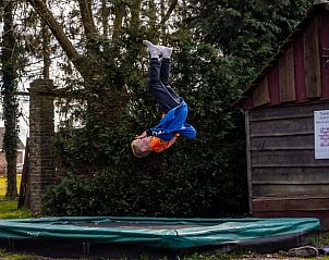 Kind springt op trampoline bij Vakantiehuisje in Roswinkel, Zuidoost Drenthe, Drenthe.