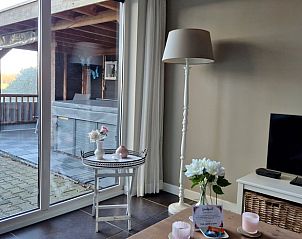 Ontspan op de veranda van het Vakantiehuisje in Dalerveen, Zuidoost Drenthe, met comfortabele ligstoelen en een luxe jacuzzi.