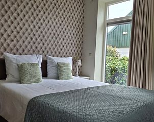 Sfeervolle slaapkamer in Vakantiehuisje in Dalerveen, Zuidoost Drenthe, met uitzicht op groene omgeving en stijlvolle inrichting.