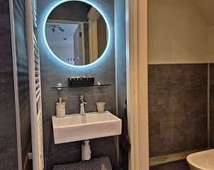 Moderne badkamer in Huisje in Dalerveen, vakantiehuis in Zuidoost Drenthe met stijlvolle wastafel en verlichte spiegel.