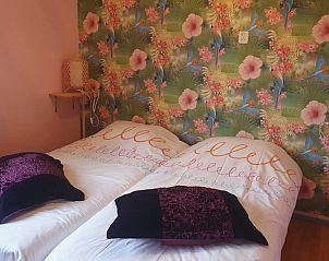 Sfeervolle slaapkamer met kleurrijk behang bij Susanna's bedandbreakfast in Emmen, ideaal voor een rustgevend verblijf.