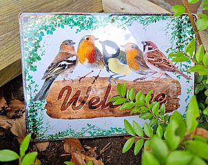 Welkomsbord met vogels bij Huisje in Emmen, vakantiehuis in Drenthe, omgeven door natuur.