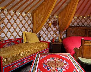 Traditionele bedden in de yurt bij Vakantiehuisje in Emmen, Drenthe, met kleurrijke details.