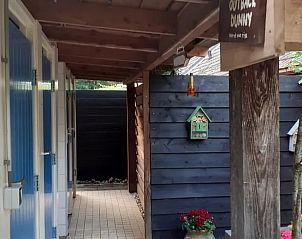 Overdekte gang naar sanitaire voorzieningen bij Vakantiehuis in Emmen, rustieke charme in Drenthe.