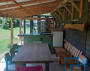Overdekt terras met eetruimte bij Huisje in Emmen, vakantieaccommodatie in Drenthe.