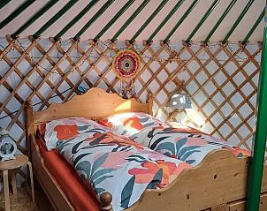 Vakantiehuis in Emmen, comfortabele slaapkamer in de yurt van de vakantiewoning in Zuidoost Drenthe, met kleurrijk beddengoed.