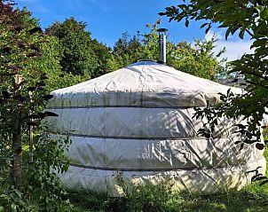 Vakantiehuis in Emmen, serene zijaanzicht van de yurt in de vakantiewoning in Zuidoost Drenthe, omgeven door groen.