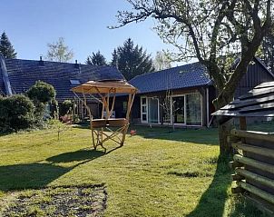 Vakantiehuis in Emmen, ruime tuin van de vakantiewoning in Zuidoost Drenthe, met houten bijgebouw en veel groen.