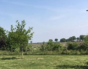 Uitzicht op het platteland vanuit Vakantiehuis in Dalen, Zuidoost Drenthe, met weidse groene velden.