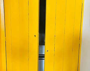 Heldere gele deuren in Huisje in Gees, Zuidoost Drenthe, geven toegang tot moderne keuken.