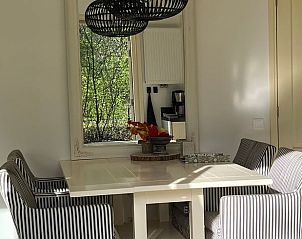 Gezellige eethoek in Huisje in Gees, vakantiehuis in Zuidoost Drenthe, met spiegel en bloemen.