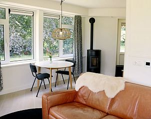 Gezellige binnenruimte van Huisje in Valthe, Zuidoost Drenthe, met zithoek en grote ramen.