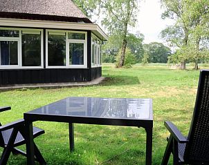 Buitenzitje bij Huisje in Valthe, Drenthe, met uitzicht op groene velden en bomen.