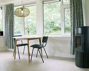 Eethoek in Huisje in Valthe, Drenthe, met moderne inrichting en uitzicht op de tuin.