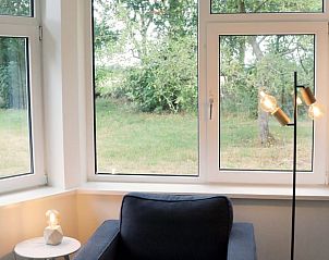 Gezellige leeshoek in Huisje in Valthe, Zuidoost Drenthe, met uitzicht op de natuur.