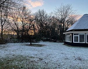 Winterlandschap rondom Huisje in Valthe, Drenthe, met besneeuwde tuin en zonsopgang.