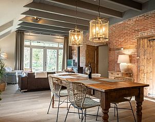 Eetkamer in Huisje in Valthe, vakantiehuis in Drenthe met rustieke houten tafel en sfeervolle lampen.