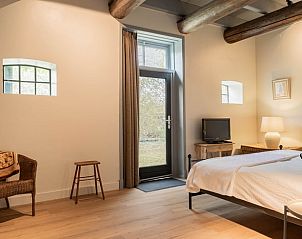 Slaapkamer in Huisje in Valthe, vakantiehuis in Drenthe met comfortabel bed en toegang tot de tuin.