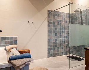 Moderne badkamer in Huisje in Valthe, vakantieaccommodatie in Zuidoost Drenthe met ruime douche en strakke tegels.