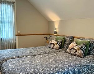 Lichte slaapkamer in Vakantiehuisje in Valthe, Drenthe met grote ramen en gezellige sfeer.