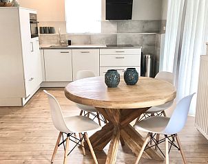 Eethoek in Vakantiehuisje in Valthe, Drenthe met houten tafel en moderne stoelen.