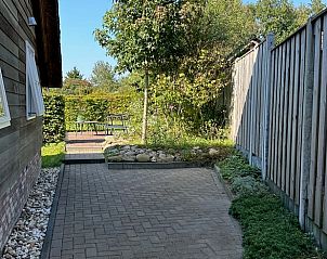 Buitenruimte van Vakantiehuisje in Valthe, Drenthe met groene omgeving en terras.