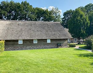 Ruime tuin van Vakantiehuisje in Valthe, Drenthe met grasveld en natuurlijke omgeving.