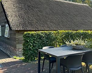 Buiten eethoek bij Vakantiehuisje in Valthe, Drenthe met houten tafel en stoelen.