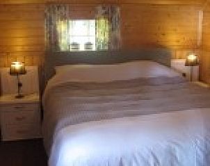 Knusse slaapkamer in Woonboerderij Kosterhoeve, Valthe, Drenthe met houten interieur en comfortabel bed.