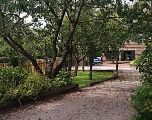 Ingang van Boerenhof in Valthe, Drenthe omgeven door weelderige natuur en bomen.