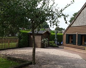 Terras en tuin van Boerenhof in Valthe, Drenthe met houten schuur en zitplek.