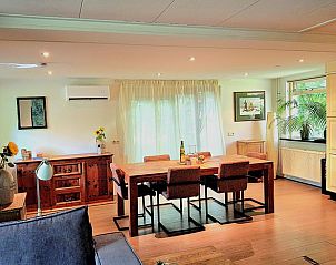 Ruime eetkamer in Vakantiehuis in Schoonoord met houten tafel en veel lichtinval.