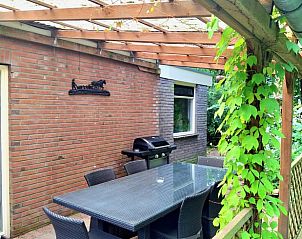 Terras met eettafel en barbecue in Vakantiehuis in Schoonoord, ideaal voor buiten dineren.