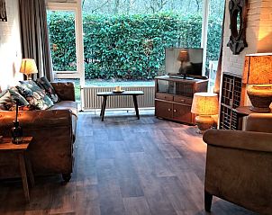 Knusse woonkamer met uitzicht op tuin in Vakantiehuis in Schoonoord, Drenthe.