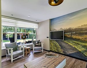 Lichte zithoek van Vakantiehuisje in Schoonoord, Drenthe met uitzicht op groene tuin.